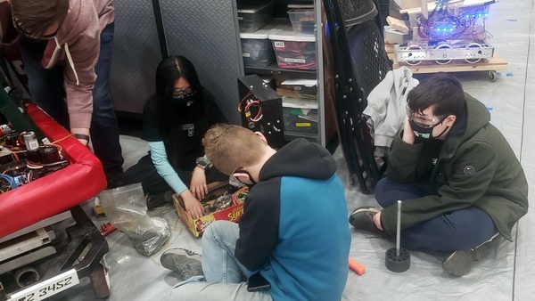 Pit crew working on robot